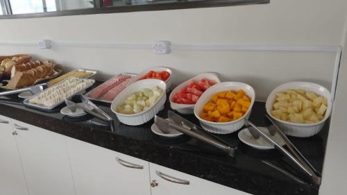 ein Buffet mit Schalen verschiedener Arten von Speisen in der Unterkunft Ora beach residence, Porto de galinhas, vista parcial do mar in Porto De Galinhas