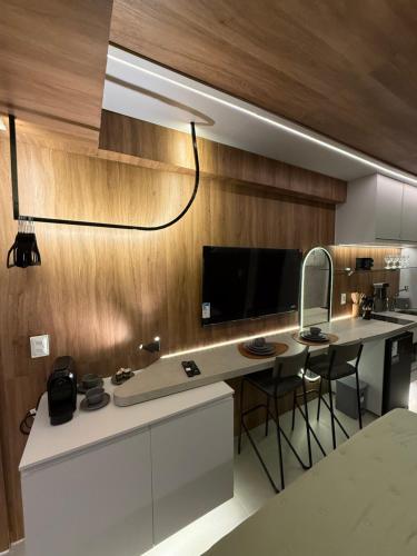 eine Küche mit einer Theke mit Stühlen und einem Spiegel in der Unterkunft Ora beach residence, Porto de galinhas, vista parcial do mar in Porto De Galinhas