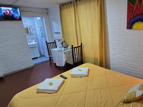 a room with a large yellow bed with a table at PRINGLES 1740 Ámbar in Yerba Buena