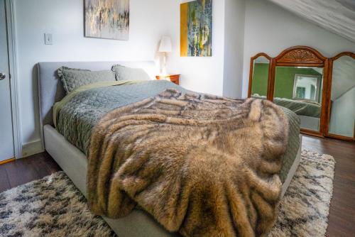 a bedroom with a large bed with a blanket and a mirror at Walk to Eats, Shops and More Prime Providence Stay! in Providence