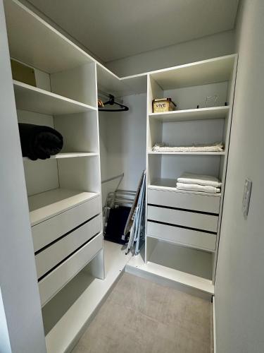 a walk in closet with white shelves at Caleta View Marítimo in Puerto Madryn