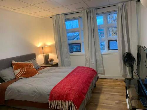 a bedroom with a bed with a red blanket on it at ArtHaus Downtown Emma Barr Unit 3BR 1BA in Whitehorse