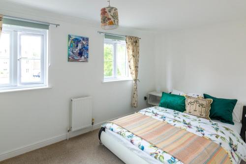 a bedroom with a bed and two windows at Peaceful 2BR Retreat w Garden Near Oxford in Witney