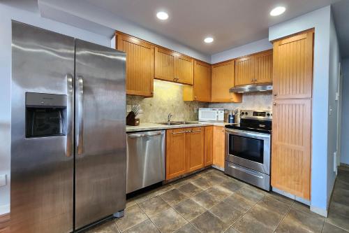 a kitchen with wooden cabinets and stainless steel appliances at Historic Bayfront! Stellar Bridge & Bay Views! Bay Dreaming in Newport