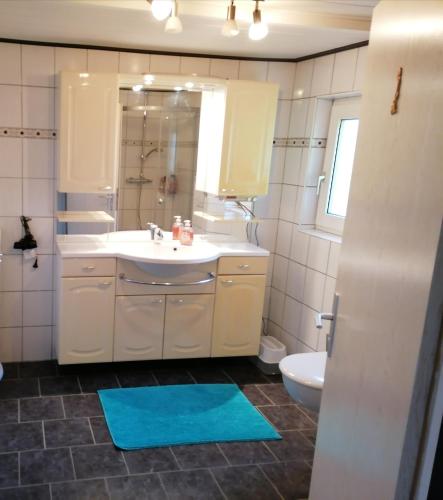 a bathroom with a sink and a toilet and a mirror at Käpt'n Brandt in Osteel