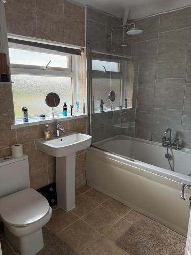 a bathroom with a tub and a toilet and a sink at Bright Private Room with Parking & Garden Access in Spennymoor