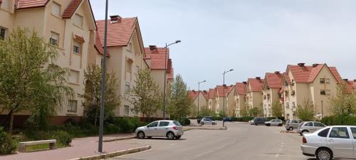 a row of houses with cars parked on the street at Ravissante appartement dans les jardins in Oulad Akkou