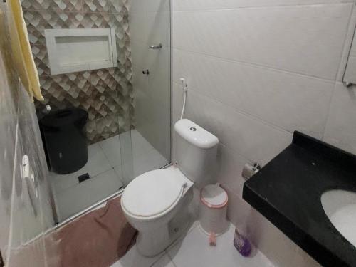 a small bathroom with a toilet and a sink at Suíte Aconchego Soure in Soure