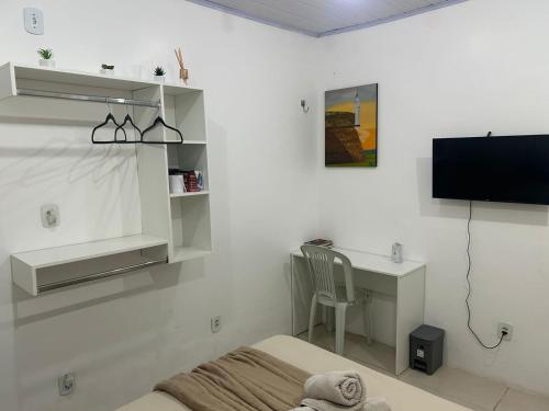 a bedroom with a bed and a desk and a tv at Studio central in Macapá