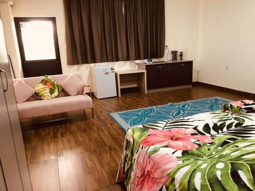 una habitación de hotel con una cama y un sofá en Samoa FINAU 685 Accomodations, en Vaitele