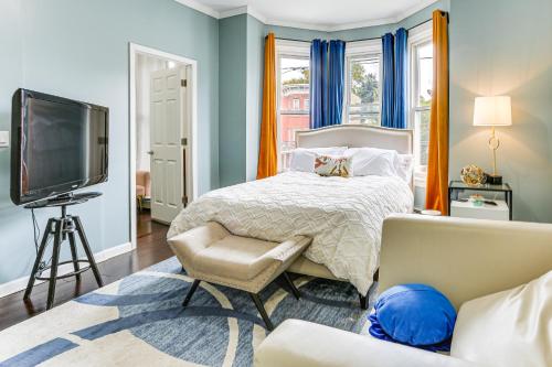 a bedroom with a bed and a tv and a couch at Explore and Work! Stylish Washington Heights Duplex in Newburgh