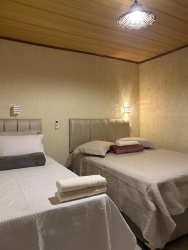 a bedroom with two beds with towels on them at Suite Tarituba 2 in Angra dos Reis