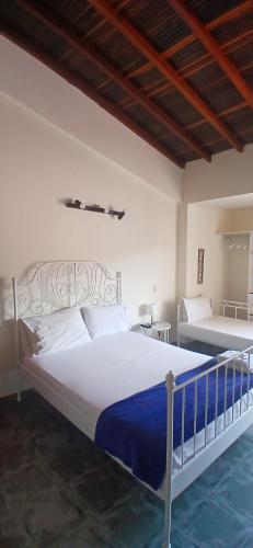 a bedroom with a large white bed with blue sheets at Sam'S VIP Hostel San Gil in San Gil