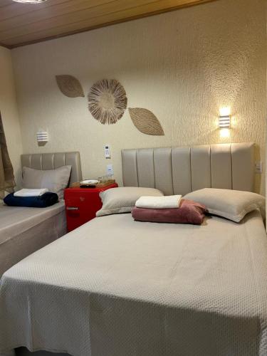 a bedroom with two beds with white sheets at Suite Tarituba 3 in Angra dos Reis