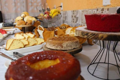 a table topped with different types of bread and cakes at Hotel Carmelita in Aparecida