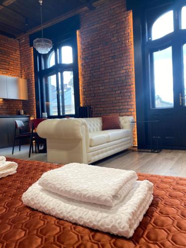 a living room with a white couch and a brick wall at Old city apart in Ivano-Frankivsʼk