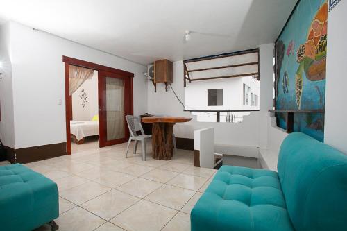 un salon avec un canapé bleu et une table dans l'établissement Hostal casa de los delfines, à Puerto Villamil