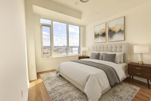 ein weißes Schlafzimmer mit großem Bett und Fenstern in der Unterkunft Paradise - 2 Bedroom modern, cozy and luxury living in Mississauga
