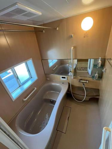 a large bath tub in a room with a window at Kuzakura in Osaka