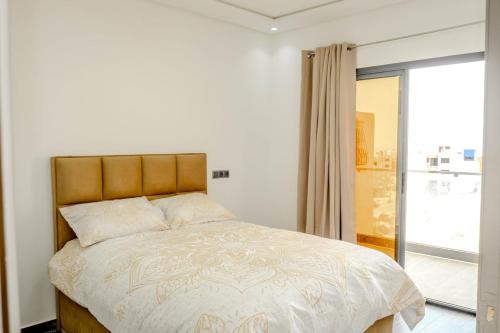 a bedroom with a large bed with a window at Imsouane ocean view in Imsouane