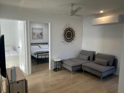 a living room with a couch and a bed at Birkdale Granny Flat in Birkdale