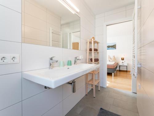 a white bathroom with a sink and a mirror at JooP in Niedernsill