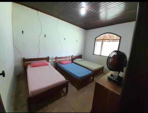 Una pequeña habitación con dos camas y una ventana. en Baia do sol na cop30, en Belém