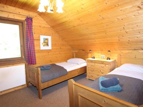 Un dormitorio con dos camas en una cabaña de madera. en Mooshausl, en Gnesau Sonnleiten