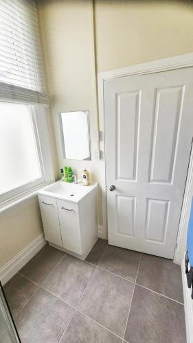a bathroom with a white door and a sink at Stay at the historic Star Hotel in Sale