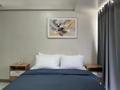 a bedroom with a bed with a blue blanket at Aspen Suites Condo in Davao City