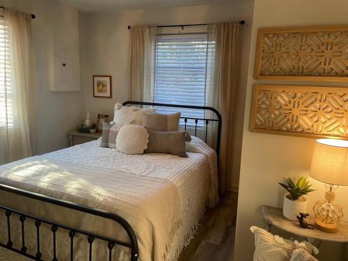 a bedroom with a bed with white sheets and a window at Cozy two-bedroom cottage close to everything! in Oak Island