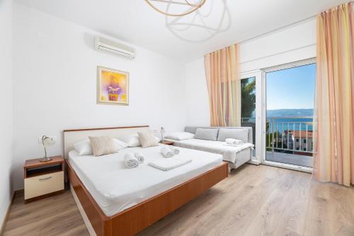 a bedroom with a bed and a large window at Apartments by the sea Duce, Omis - 946 in Duće