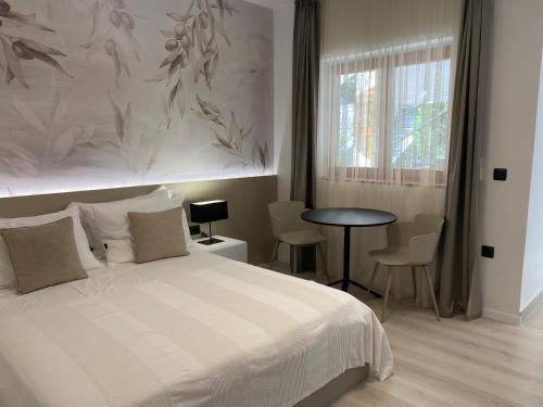 een slaapkamer met een bed en een tafel met stoelen bij Apartments by the sea Mali Losinj (Losinj) - 3444 in Veli Lošinj