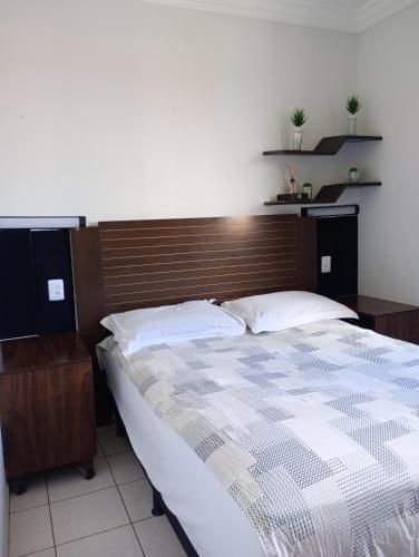 a bedroom with a large bed with a wooden headboard at Apto Completo Aparecida de Goiânia in Aparecida de Goiânia