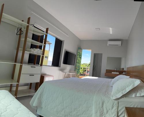 1 dormitorio con cama, lavabo y ventana en Hotel Conceito, en Tareco