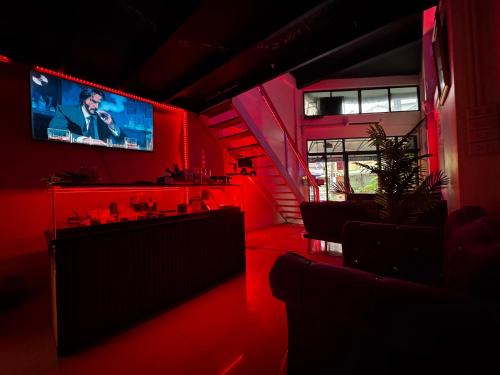 Una habitación con iluminación roja y un televisor en la pared. en W33d Gallery Pattaya, en Pattaya South