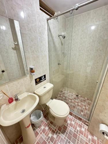 a bathroom with a toilet and a sink and a shower at San Alejo in Tuluá