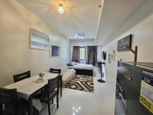 sala de estar con mesa y habitación con cama en Comfort Homey Studio with Fresh Mountain Air by Cherisia's Hideaway, en Baguio