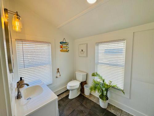 une salle de bains blanche avec toilettes et lavabo dans l'établissement Alwaves Family 3 Bedroom Beach Apartment, à Wildwood