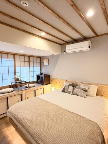 a bedroom with a large bed and a kitchen at Tsuruhashi 1F 9 min walk &3BR Apt for 6&Near Enba Natural Onsen&JR Direct to Namba, Nara & USJ in Osaka