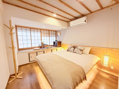 a bedroom with a large bed and a window at Tsuruhashi 1F 9 min walk &3BR Apt for 6&Near Enba Natural Onsen&JR Direct to Namba, Nara & USJ in Osaka