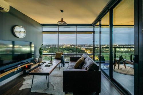 a living room with a couch and a large window at Horizon King-bed Lux Apt Free Parking in Sydney