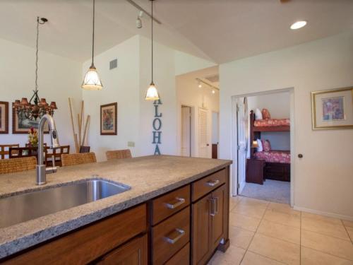 a kitchen with a sink and a living room at Wailea Grand Champions 84 in Wailea