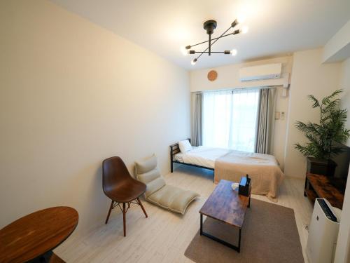 a bedroom with a bed and a chair and a table at REVISION Ebiyama-tei - Vacation STAY 15809 in Hiroshima