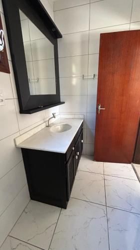 a bathroom with a sink and a mirror at Mirante Luz Floripa in Florianópolis