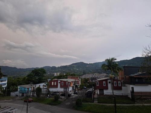 a town with houses and mountains in the background at Loft, total tranquility in Dosquebradas
