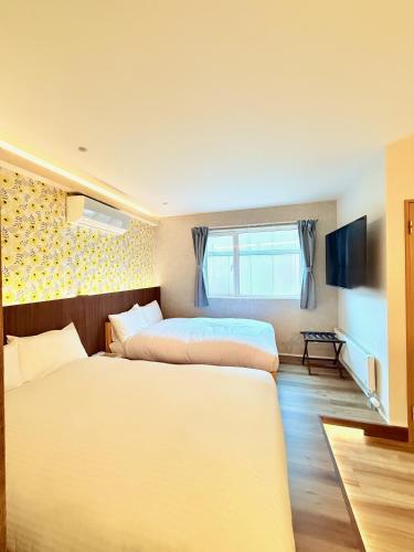 a bedroom with two beds and a window at THE LOBS, RUSUTSU in Kimobetsu
