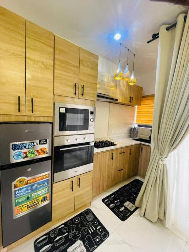 kuchnia z drewnianymi szafkami i kuchenką z piekarnikiem w obiekcie Leeds 2 apartment w mieście Lagos
