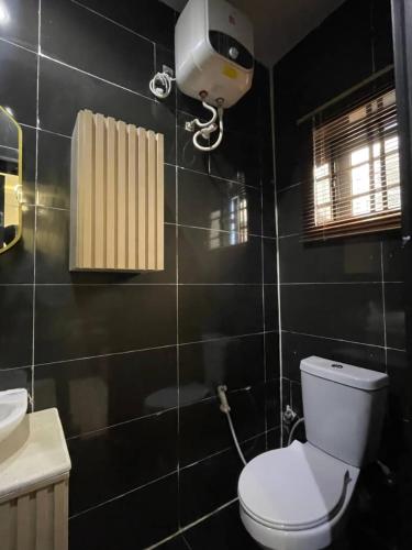 łazienka z toaletą i kamerą na ścianie w obiekcie Leeds 2 apartment w mieście Lagos