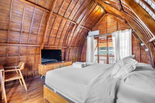 a bedroom with a bed and a tv in a room at Ammara Viila Jimbaran in Nusa Dua